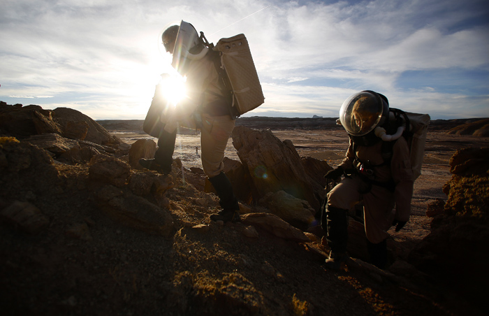 Melissa Battler, left, a geologist and commander and Csilla Orgel, a geologist on Crew 125 EuroMoonMars B mission, climb a rock formation to collect geologic samples to be studied at the Mars Desert Research Station (MDRS) outside Hanksville in the Utah desert, March 2, 2013. The MDRS aims to prepare for a human exploration of Mars using the desert location’s Mars-like terrain and appearance to simulate working conditions on the red planet. Scientists, students and enthusiasts work together to develop field tactics and study the terrain whilst wearing spacesuits and carrying an air supply pack and live together in a small communication base with limited space and supplies. Picture taken March 2, 2013. REUTERS/Jim Urquhart  (UNITED STATES)