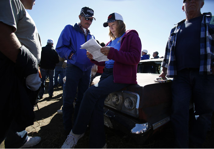 Potential buyers and car enthusiast Rick Fitzler, left, and Gail Meisner monitor the bids as the vintage automobiles from the Lambrecht Collection are put up for auction in Pierce, Nebraska, September 28, 2013. Over 500 classic cars and trucks from an inventory collected by Ray and Mildred Lambrecht will be sold over the weekend. REUTERS/Jim Urquhart (UNITED STATES)
